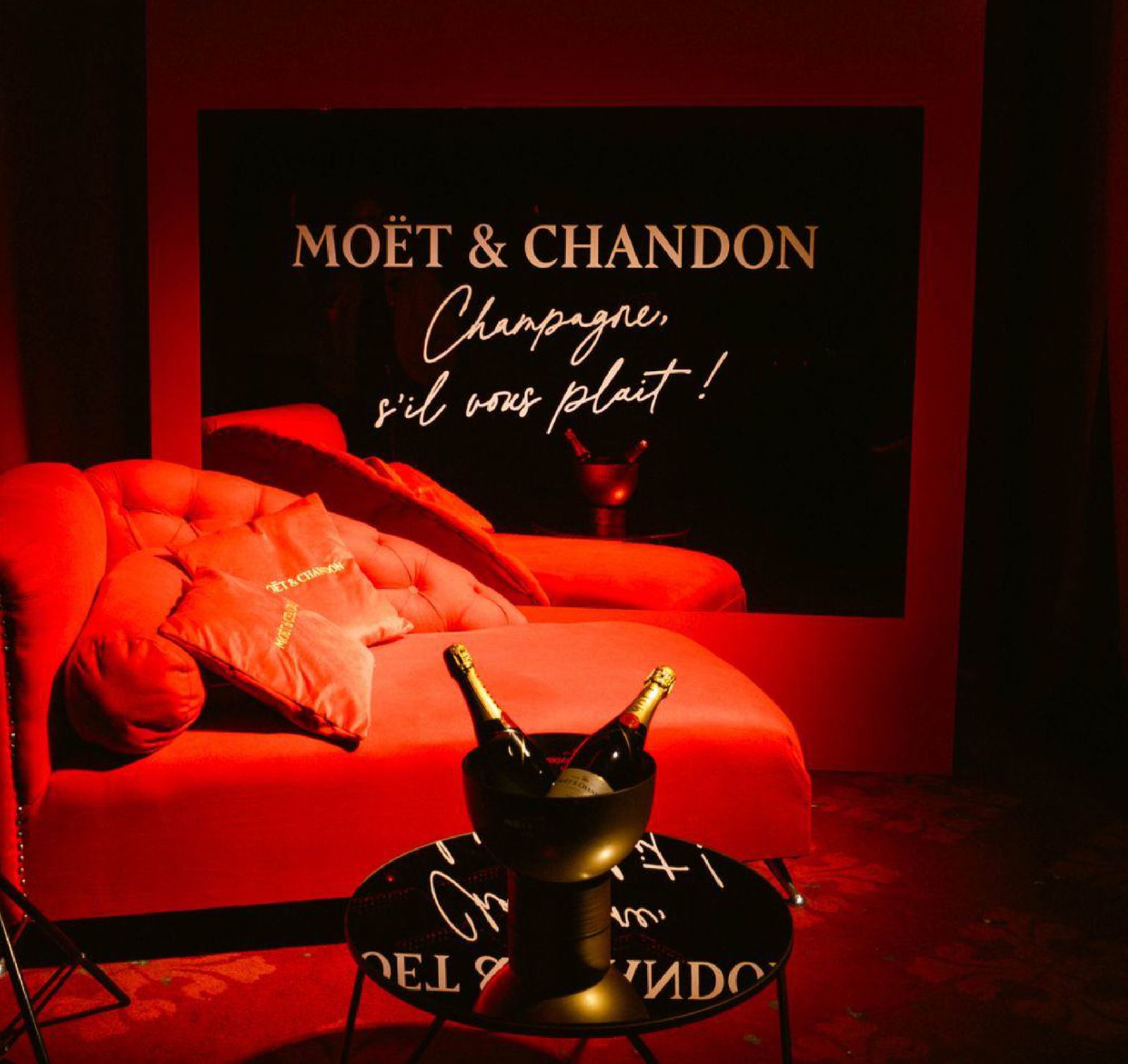 Ambientación de Moët & Chandon en Caramelo, con sillón rojo y champagne.