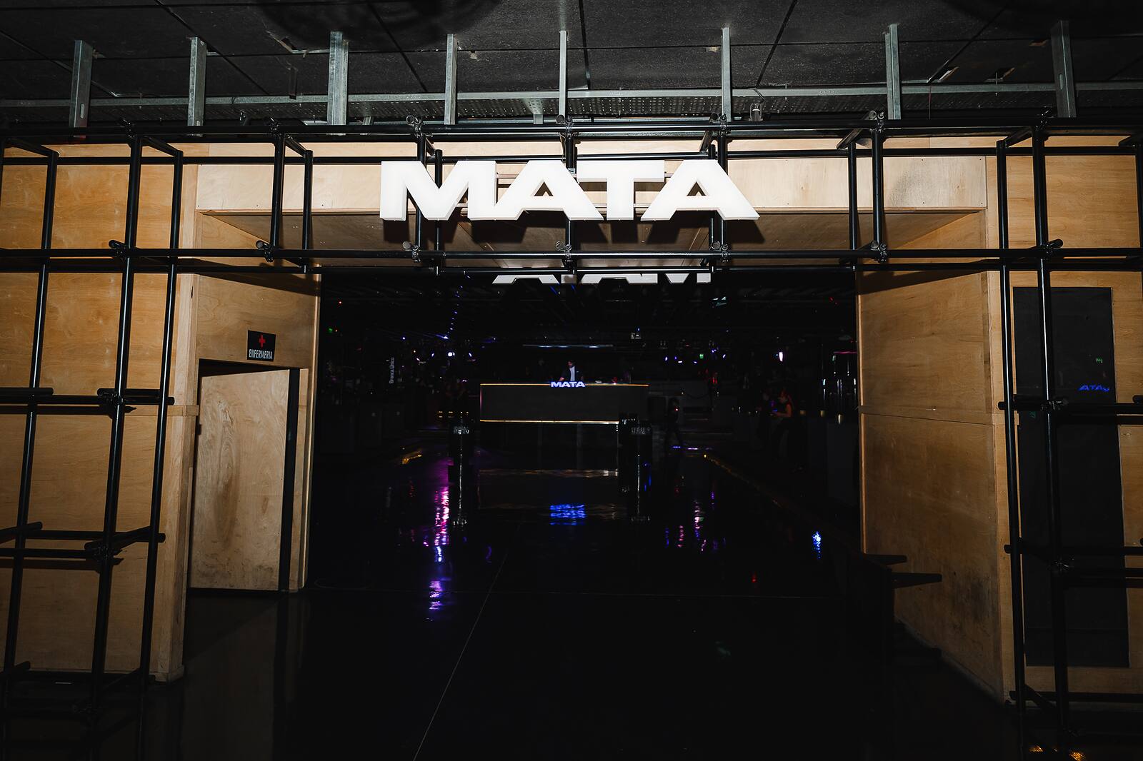 Ingreso de Mata Club con cartel iluminado.