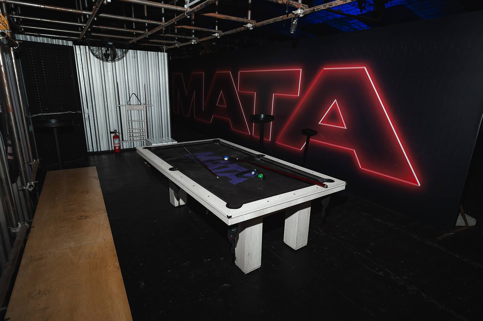 Sector loft de Mata Club con mesa de pool y cartel de neón.